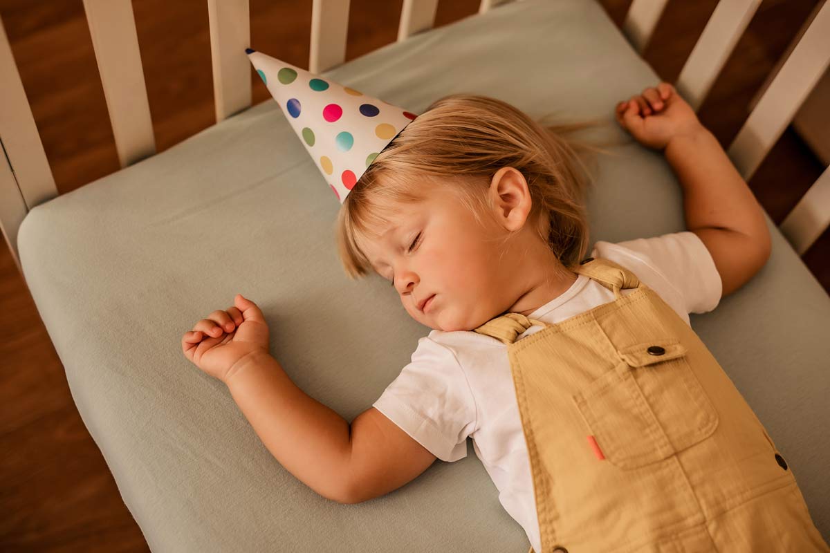a-two-year-old-boy-in-a-festive-paper-hat-sleeps-i-2024-09-20-23-45-29-utc